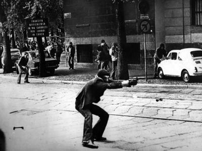 Milano, via De Amicis 14 maggio 1977: Giuseppe Memeo punta una pistola contro la polizia durante una manifestazione di protesta. Quest’immagine è diventata l’icona degli anni di piombo. (foto di Paolo Pedrizzetti)